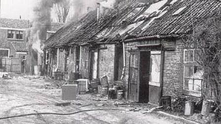 Brand in steegwoningen tussen Voorheuvel en Leliestraat, met rokende daken en beschadigde gevels.