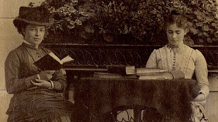 Twee vrouwen lezen een boek.