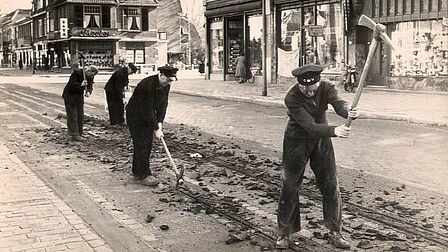 Arbeiders hakken tramrails uit de Slotlaan in Zeist voor wegverbreding.