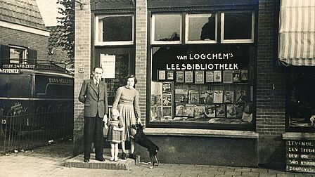 Echtpaar met kind en hond in de deuropening van hun winkel
