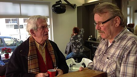 Dick en Broos in gesprek in de kapperszaak.